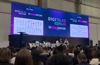 Palco com grande telão com o logo do Digitalks e o público assistindo a palestra